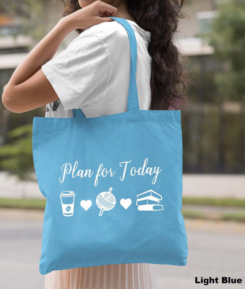 May include: Light blue tote bag with the text "Plan for Today" in white. The bag features white icons of a coffee cup, yarn ball, and a stack of books.