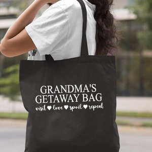 Pu&ograve; includere: Borsa tote nera con testo bianco che dice "Grandma's Getaway Bag visit love spoil repeat".