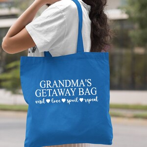 Pu&ograve; includere: Una borsa tote blu reale con testo bianco che recita "Grandma's Getaway Bag visit love spoil repeat".