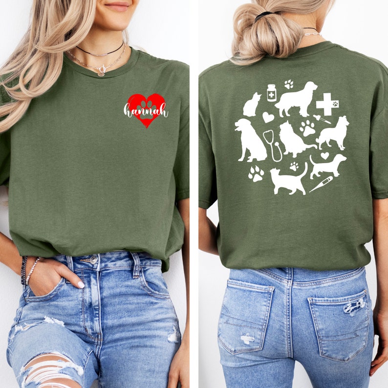 Op de afbeelding: Een groen T-shirt met een rood hart en de naam "Hannah" op de voorkant. De achterkant van het shirt heeft een wit ontwerp van een kat, een hond en andere huisdiergerelateerde iconen.