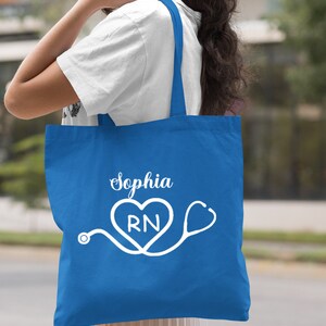 May include: A royal blue tote bag with white text that says "Sophia RN" and a stethoscope with a heart.