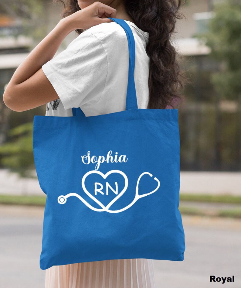 May include: A royal blue tote bag with white text that says "Sophia RN" and a stethoscope with a heart.