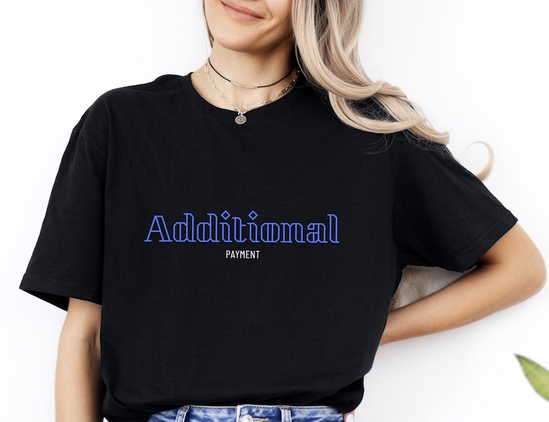 Op de afbeelding: Zwart T-shirt met de tekst "Additional Payment" in blauwe omrande letters.