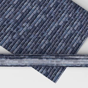 May include: A roll of blue and gray patterned wrapping paper with a textured tile design. The paper is rolled up and the end is visible.