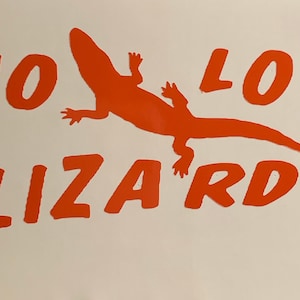 May include: Orange vinyl sticker with the text "NO LIZARDS" and a silhouette of a lizard.