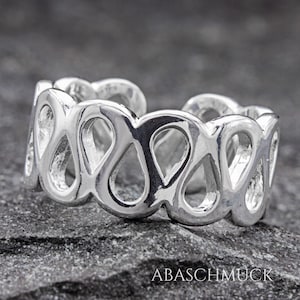 Può includere: Anello per dita dei piedi in argento con un delicato design traforato che presenta un motivo ripetuto di forme a goccia.