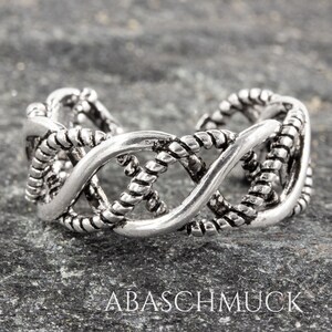 Puede incluir: Anillo de dedo del pie de plata con un diseño trenzado. El anillo es abierto y ajustable.