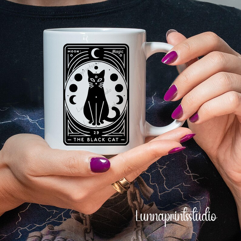 May include: White ceramic mug with a black and white illustration of a black cat with a crescent moon and stars. The text "The Black Cat" is printed on the mug.