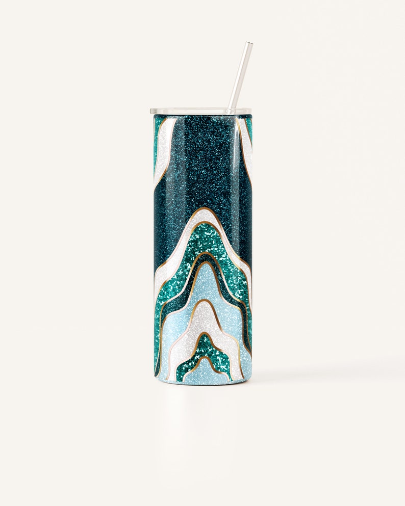 May include: A teal glitter tumbler with a wavy design in shades of teal, white, and light blue, outlined in gold. The tumbler has a silver lid and a silver straw. The design resembles an abstract landscape.