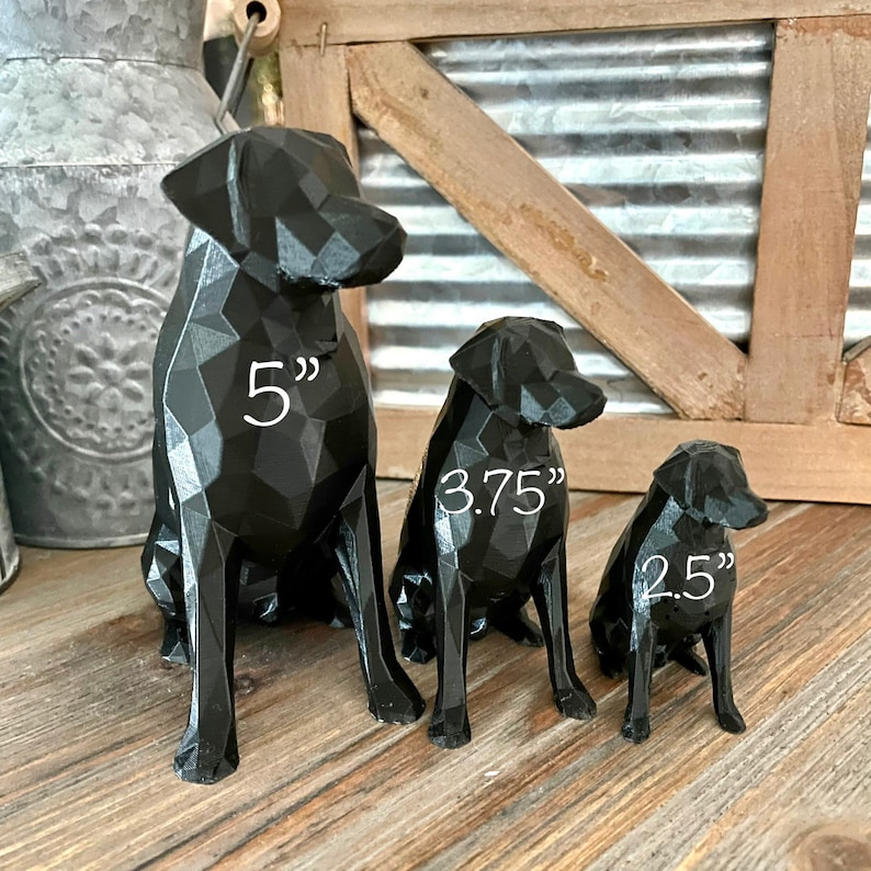 K&ouml;nnte beinhalten: Drei schwarze Labrador-Hundefiguren, die gr&ouml;&szlig;te ist 5 Zoll gro&szlig;, die mittlere 3,75 Zoll und die kleinste 2,5 Zoll.
