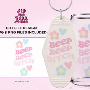 Könnte beinhalten: Ein weißer Schlüsselanhänger mit einem rosa-weißen Ombre-Design, auf dem "Beep Beep Bitch" steht, mit einem Blumen- und Herzdesign.