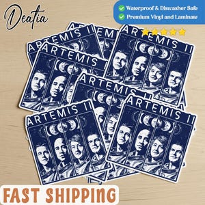 May include: A collection of rectangular stickers featuring the text "ARTEMIS II" and portraits of astronauts. The stickers have a dark blue background with white text and images. The stickers are waterproof and dishwasher safe, made of premium vinyl and laminate.