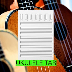 May include: A blank ukulele tab sheet with the words "UKULELE TAB" printed in green on a white background. The sheet is in front of a group of ukuleles.