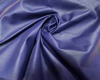 May include: A close-up of a smooth, deep blue fabric with a soft, silky texture. The fabric is draped and folded, creating a luxurious and elegant look.
