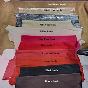 May include: A variety of suede leather swatches in different colors, including plum, tan brown, glitter tan, glitter black, off white, white, hot pink, red, light red, orange, black, and brown.