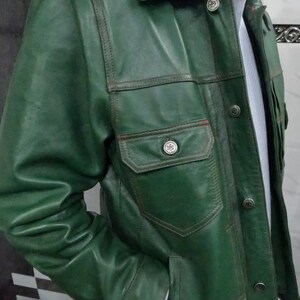 May include: A green leather jacket with a button-up front and multiple pockets. The jacket has a classic denim style.