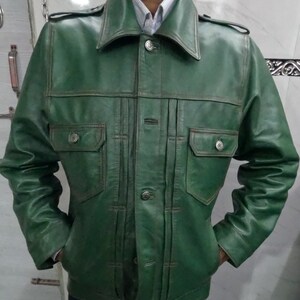 May include: A green leather jacket with a button-up front and two flap pockets. The jacket has a collar and long sleeves.