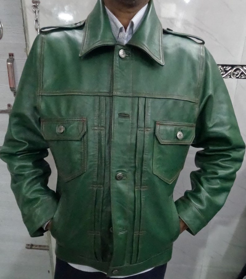 May include: A green leather jacket with a button-up front and two flap pockets. The jacket has a collar and long sleeves.