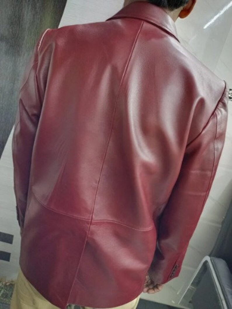 May include: A burgundy leather blazer with a classic design. The blazer has a smooth, polished finish and a tailored fit.