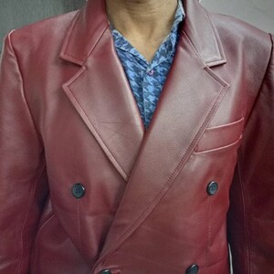 May include: A double-breasted burgundy leather blazer with a button closure.