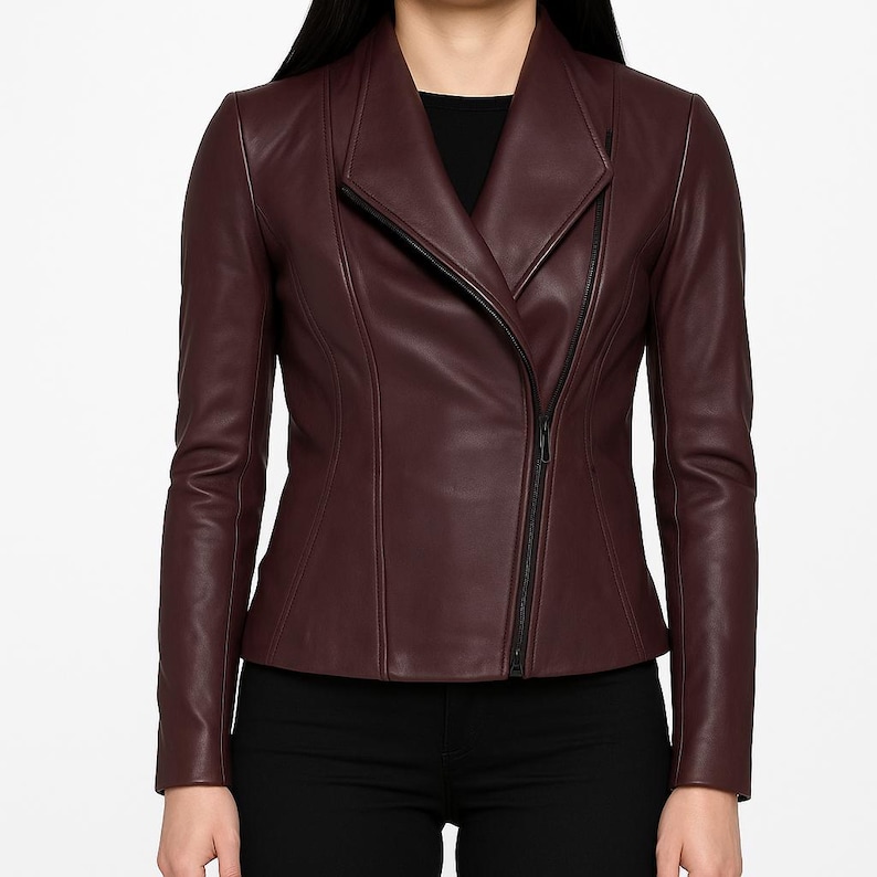 May include: A burgundy leather jacket with a zipper closure and a collar that can be worn up or down.