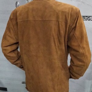 May include: A brown suede jacket with a button-up front and long sleeves.