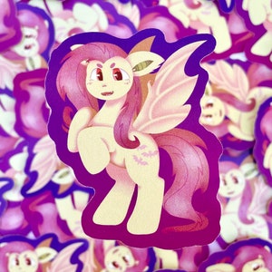 May include: A sticker featuring a cartoon purple and pink pony with bat wings and a bat tattoo. The pony has a pink mane and tail and is standing on a purple background.