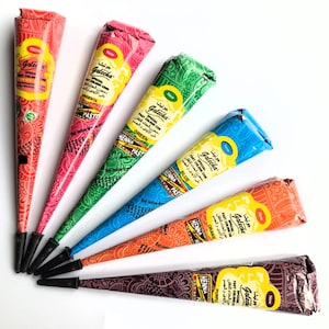 May include: Six henna cones in different colors: magenta, green, blue, orange, purple, and brown. Each cone has a label with the brand name "Golecha" and the color of the henna. The cones are arranged in a fan shape on a white background.