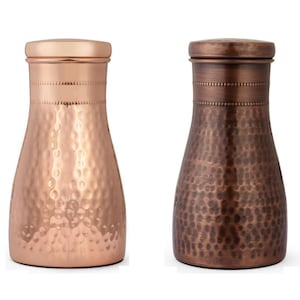 May include: Two copper-colored, hammered-finish water bottles with matching lids. One bottle is a bright copper color, and the other is a darker, antique copper color. Both bottles have a similar shape and design.