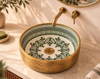 May include: A round vessel sink featuring a textured gold exterior and an interior decorated with a green and white botanical pattern. The sink includes a central brass drain and is paired with a matching brass wall-mounted faucet and handle.