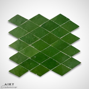 May include: A green Moroccan tile mosaic in a diamond pattern. The tiles are arranged in a staggered pattern, creating a geometric design. The tiles are a deep green colour with a slightly textured surface.