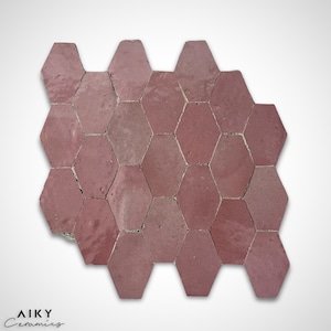 Peut inclure: Gros plan sur un motif de carreaux hexagonaux de couleur rose poussiéreux. Les carreaux sont disposés en nid d'abeille, créant une surface texturée.