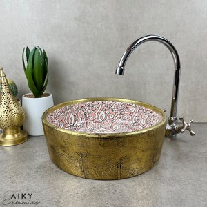 アンティーク モロッコ職人のセラミック シンク、手描きのピンクの花のモチーフとつや消し真鍮の外装 - あなたのお風呂に時代を超越したエレガンスを吹き込みます。
