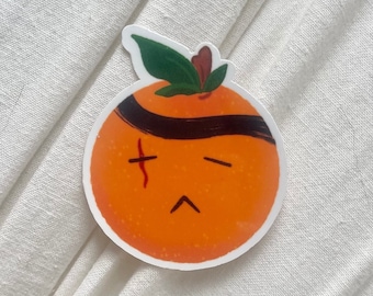 May include: A sticker of an orange with a black eye patch and a red scar. The orange has a sad expression.