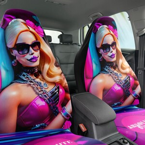 May include: Two car seat covers featuring a pink and blue design with a woman wearing sunglasses and a skull makeup design. The text "ABSOLUTELY" is visible on one of the covers.