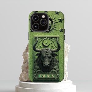 May include: Green phone case featuring a detailed relief of a bull, the Taurus zodiac sign. The case has a textured surface with stars and a crescent moon design. The word "TAURUS" is displayed at the bottom of the case.