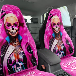 May include: Pink car seat covers featuring a stylized illustration of a woman with pink hair and a skull face. The design includes a black jacket, blue accents, and the words "Candy Girl" on the seat.