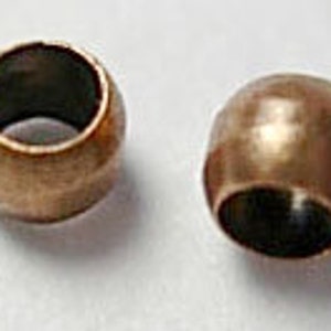 May include: Two gold-toned metal bead caps, each with a smooth, rounded surface and a hole in the center.