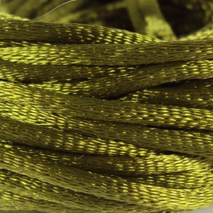 Può includere: Primo piano di un'bobina di filo da ricamo verde oliva.