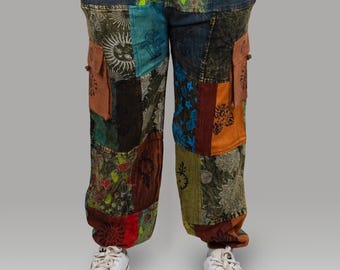May include: Patchwork pants with a variety of patterns and colors, including blue, green, orange, and brown. The pants have a drawstring waist and two cargo pockets. The pants are worn with white sneakers.