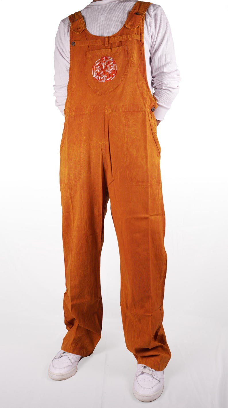May include: A pair of orange overalls with a red and white circular design on the front pocket. The overalls have a relaxed fit and are made of a soft, comfortable fabric.