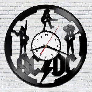 May include: Black vinyl record clock featuring the AC/DC logo and silhouettes of the band members. The clock face is white with black numbers and hands.