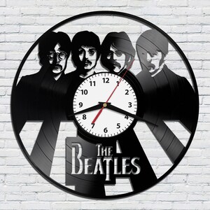 May include: Black vinyl record clock featuring a silhouette of the Beatles with the band's name "The Beatles" printed below the clock face.