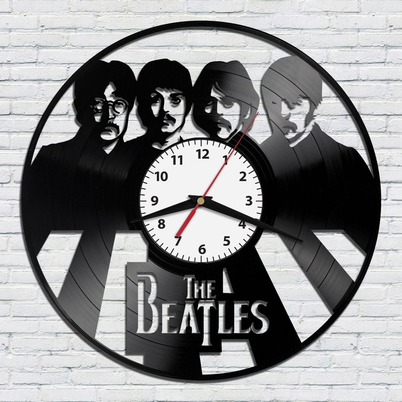 May include: Black vinyl record clock featuring a silhouette of the Beatles with the band's name "The Beatles" printed below the clock face.