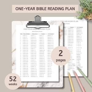 May include: A one-year Bible reading plan, featuring a weekly schedule with 52 weeks. The plan is printed on two pages and held together with a binder clip. Colored pencils are visible.