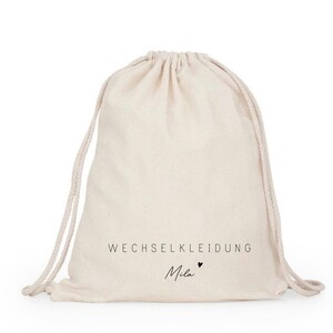 May include: A white drawstring bag with the text "WECHSELKLEIDUNG Mila" printed on it.