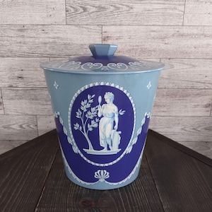 May include: A white ceramic mug with a black handle and the text "But First, Coffee" in a bold, black font. The mug is likely designed for hot beverages and has a glossy finish.