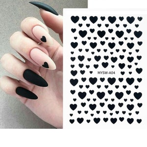 Pode incluir: Adesivos pretos para unhas com uma folha de pequenos corações pretos. A folha tem o texto "MYSW-A04" impresso nela.