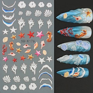 Könnte beinhalten: Nagelkunst-Aufkleber mit maritimen Designs. Sie zeigen weiße Muscheln, Seesterne, Seepferdchen und Korallen. Beispiele für Nagelkunst mit Ozeanwellen und Meeresbewohnern sind ebenfalls abgebildet. Der Text "5D-K176" ist sichtbar.