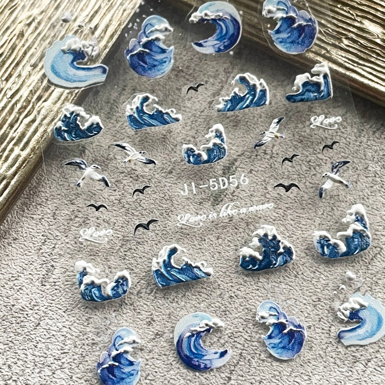 May include: A sheet of clear sticker paper with blue and white wave designs and black seagull silhouettes. The text "JI-5D56" is printed on the sheet.